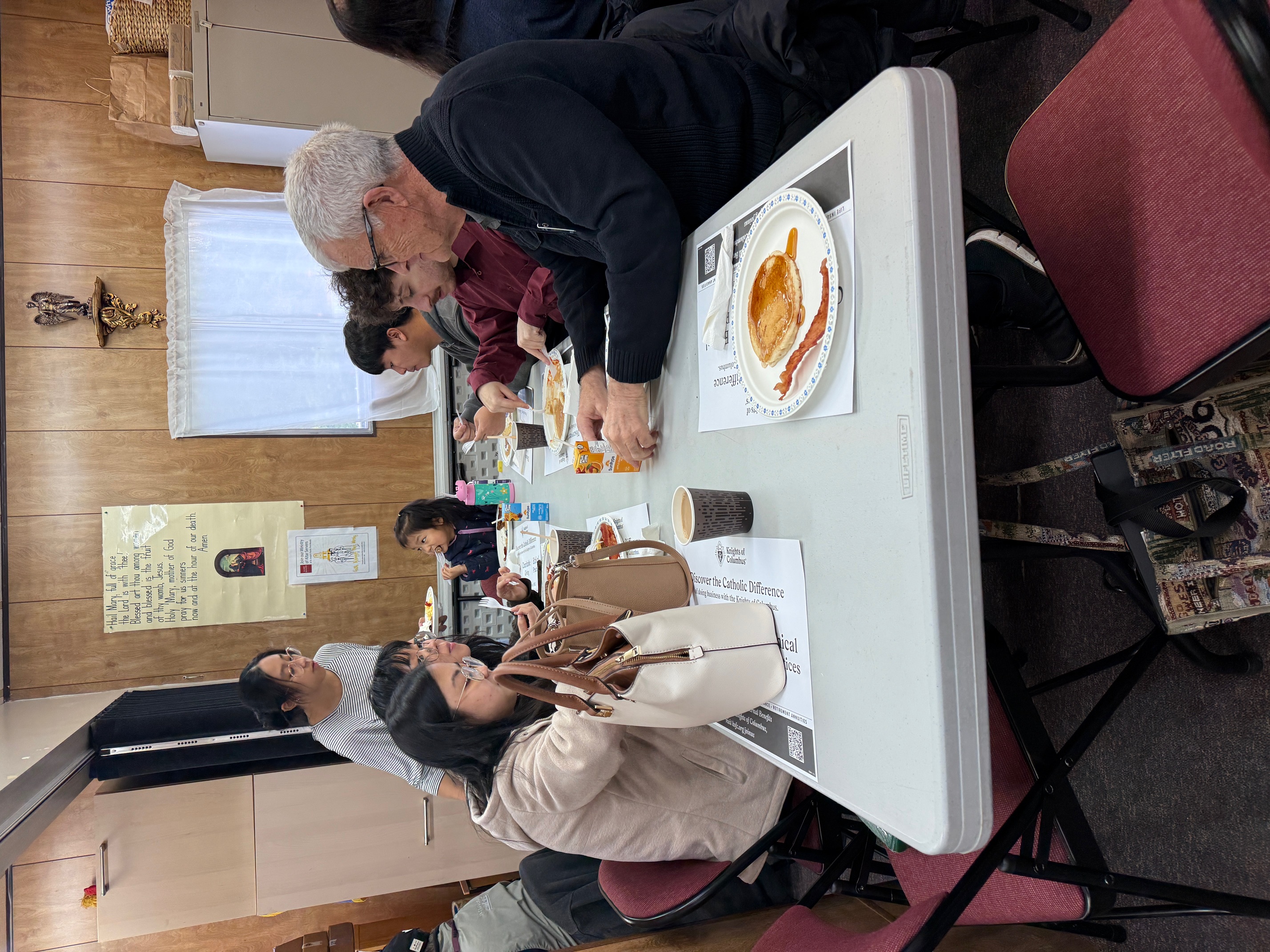 Parishioners seated at a table enjoying breakfast