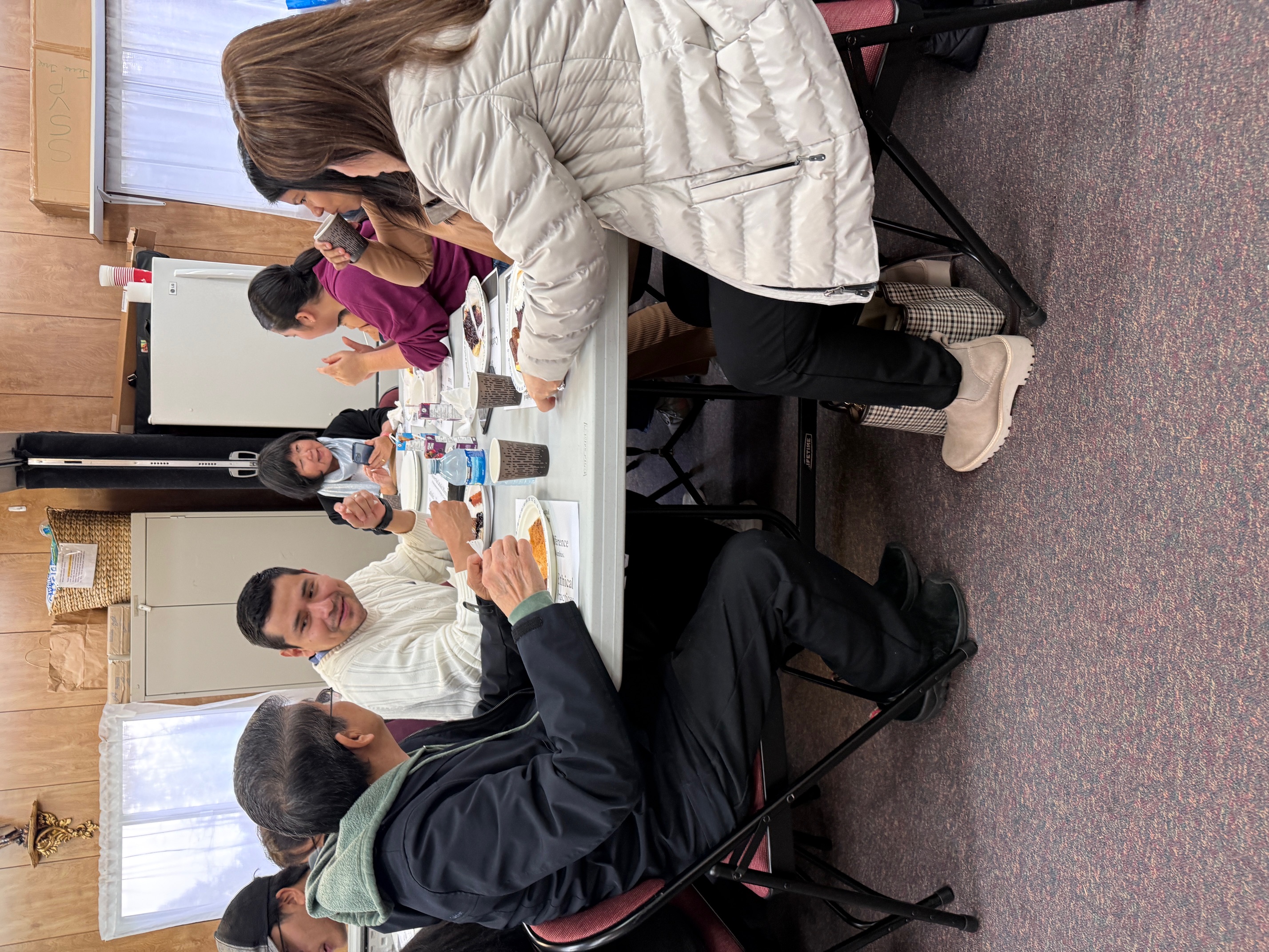 Families and parishioners eating breakfast together at one table