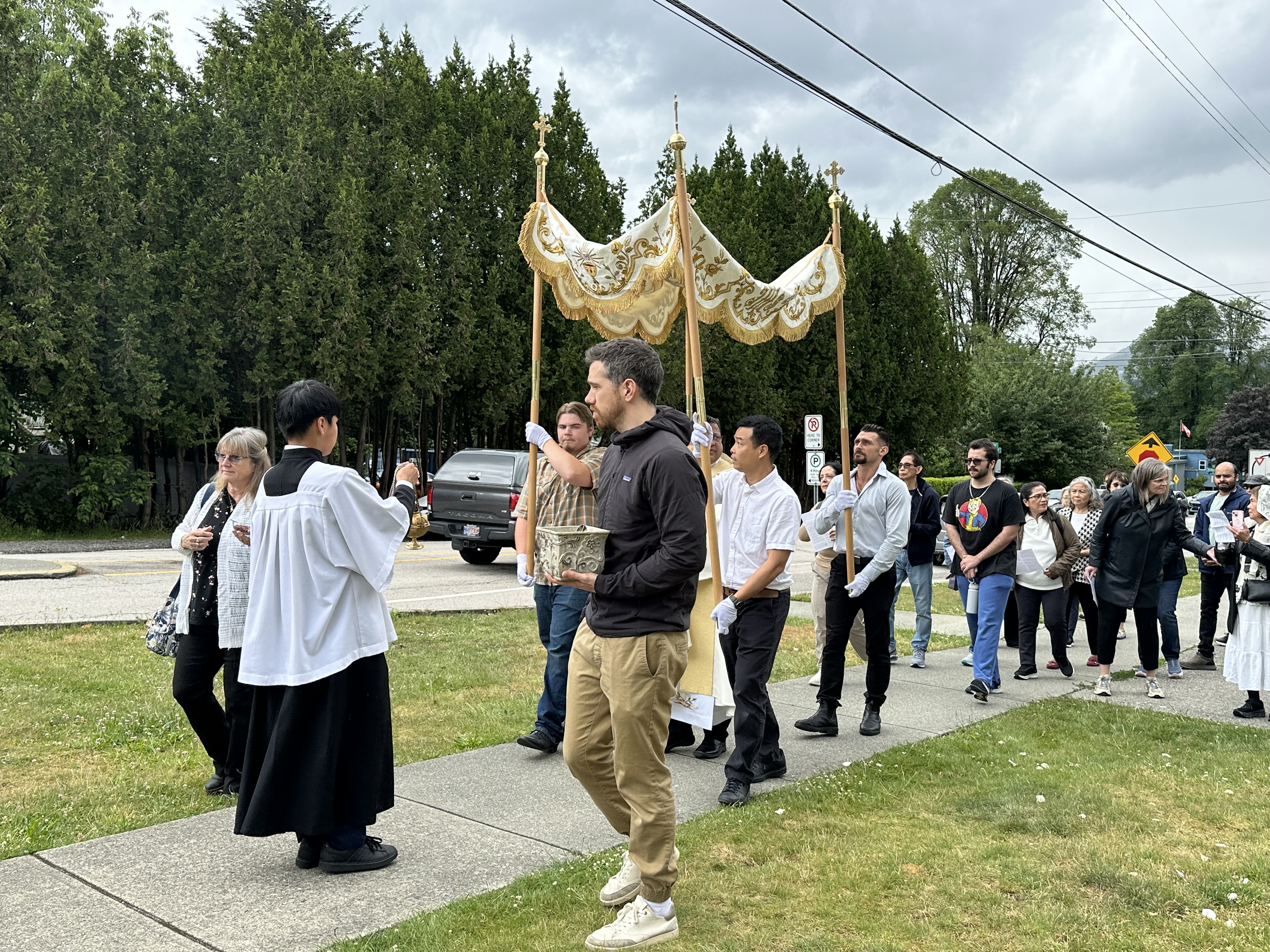The Eucharistic procession leaving St. Joseph Parish under cloudy skies