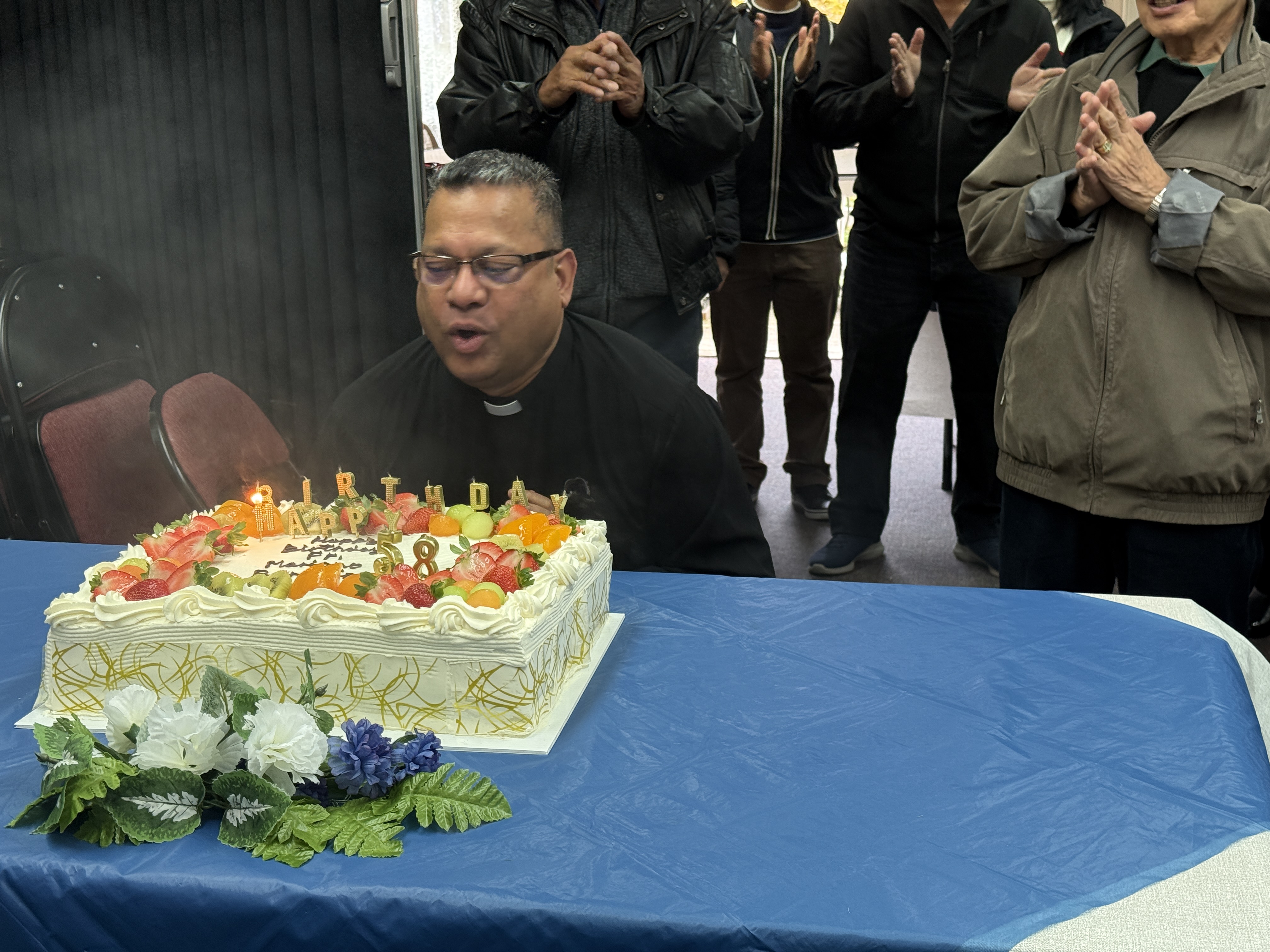 Father Mariano getting ready to blow out candles