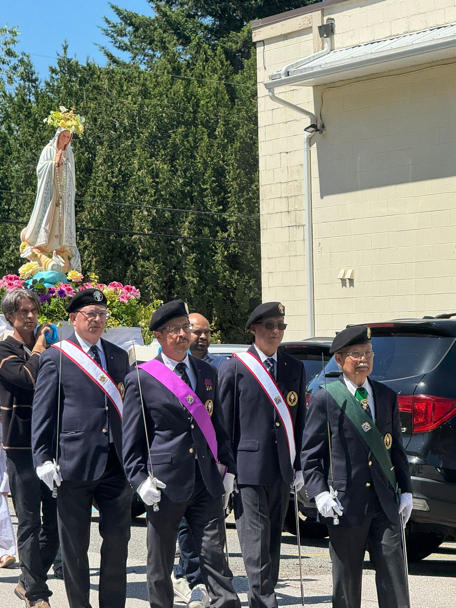 Knights walking in formation ahead of Mary's statue