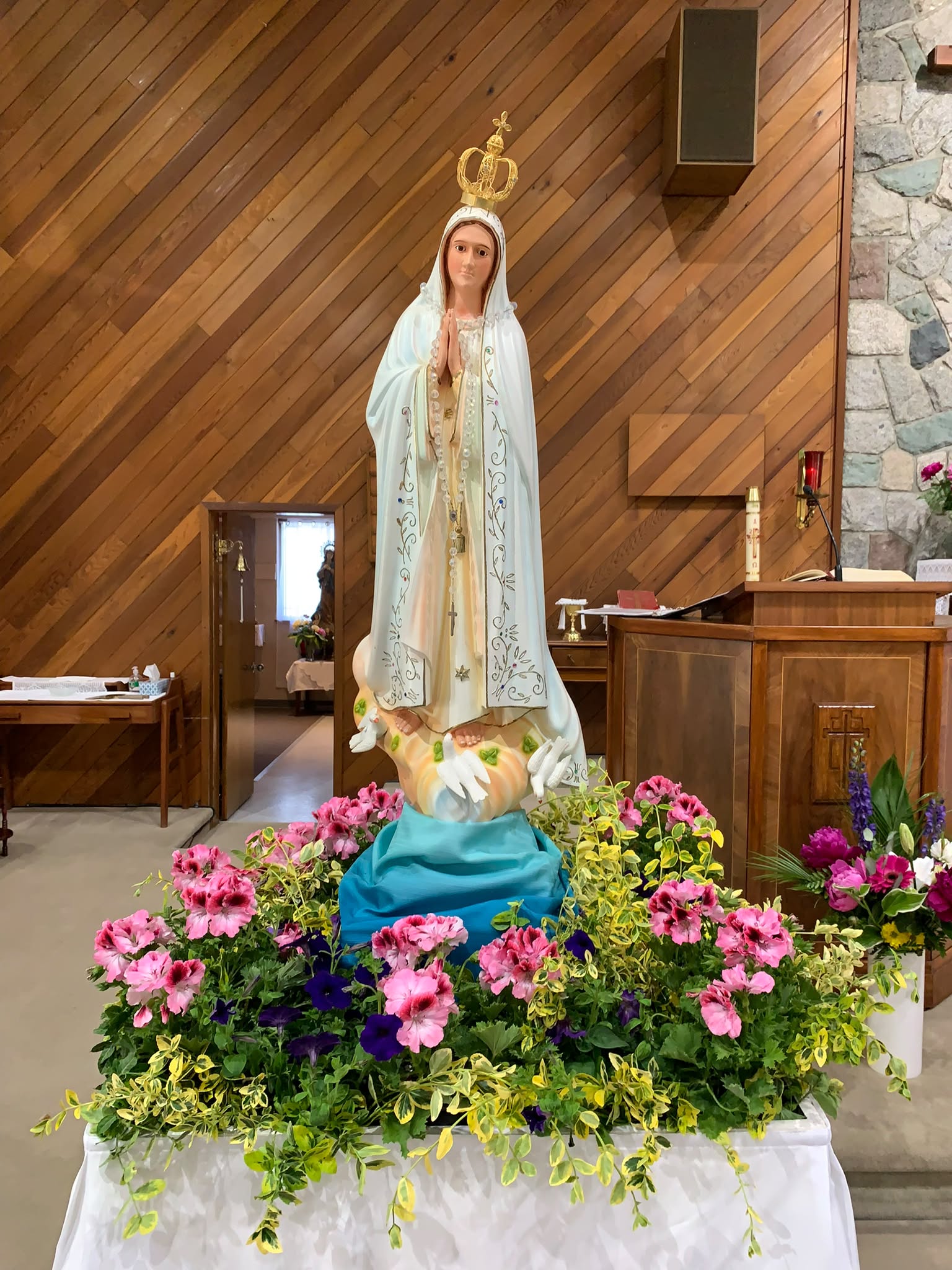 Close view of Mary's statue surrounded by flowers