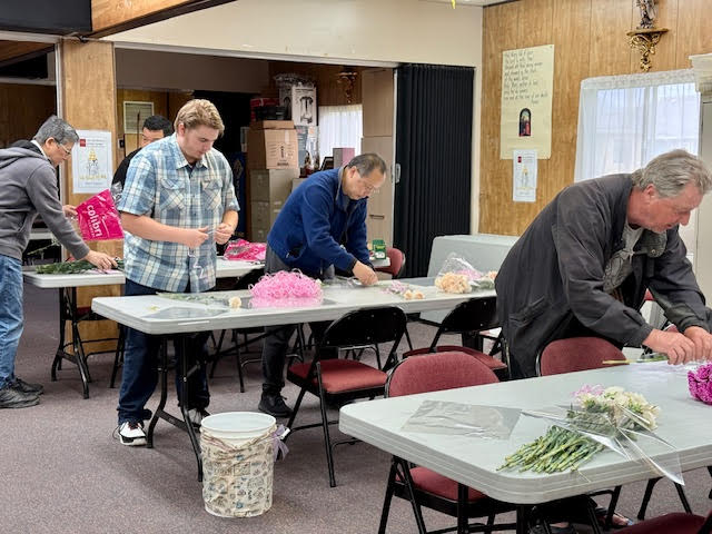 Rows of tables with Knights wrapping flowers
