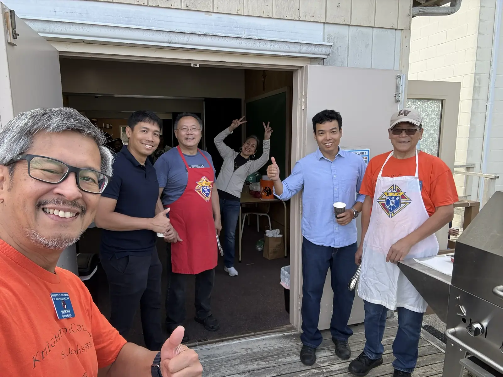 Picnic volunteers smiling together outside the parish kitchen