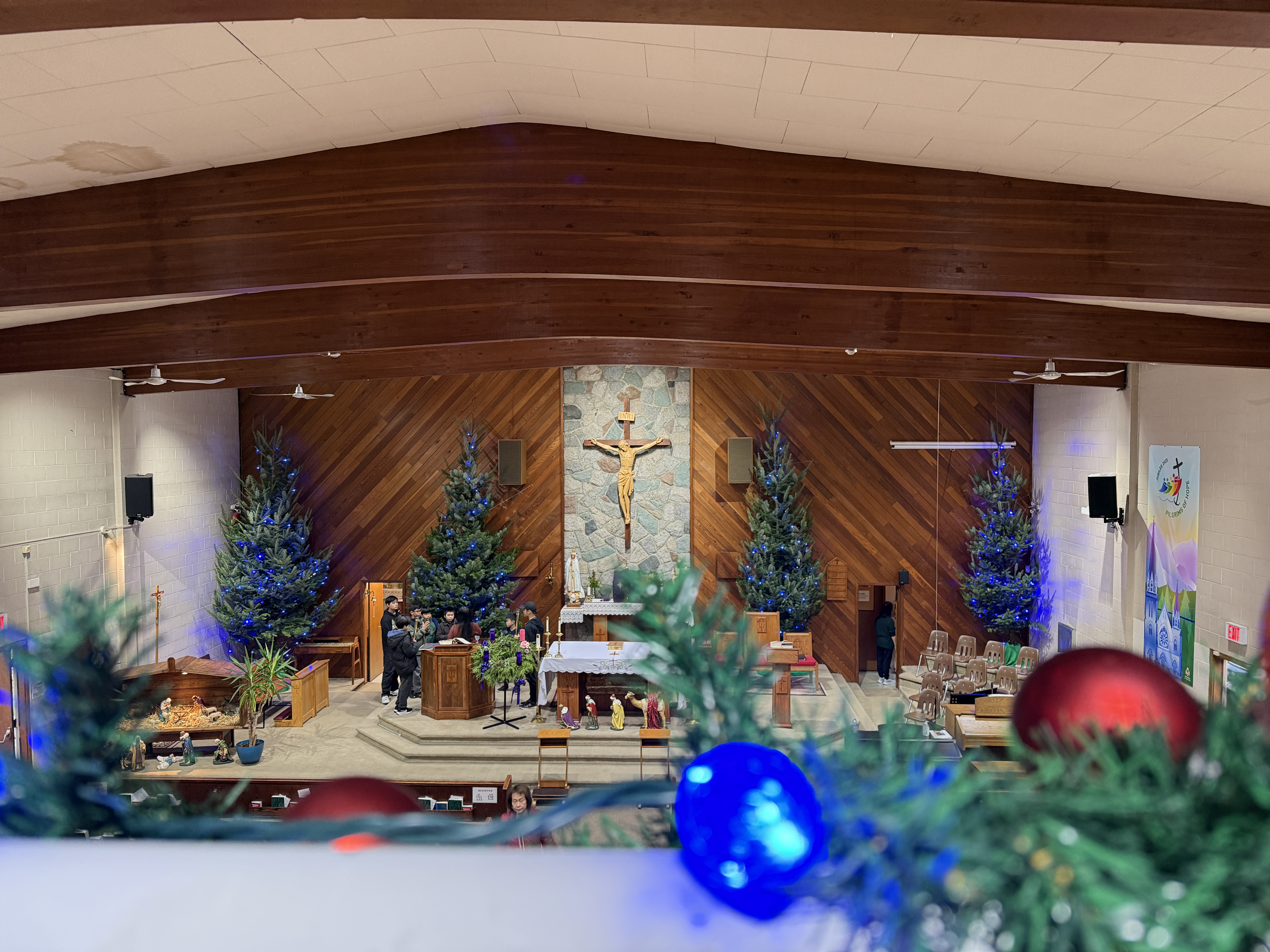 Trees standing tall and fully decorated in the sanctuary.
