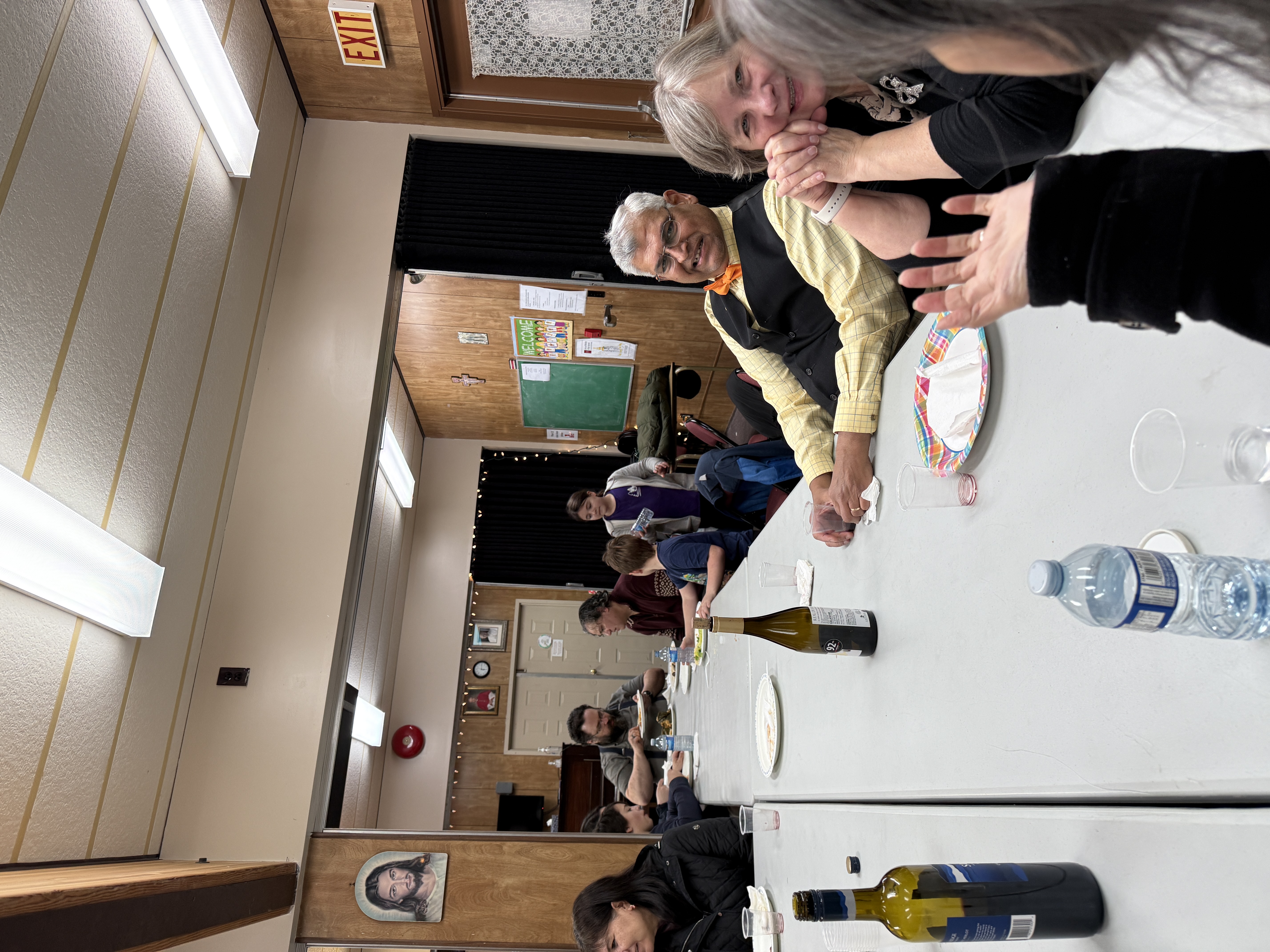 Knights and families chatting along the long table with empty plates