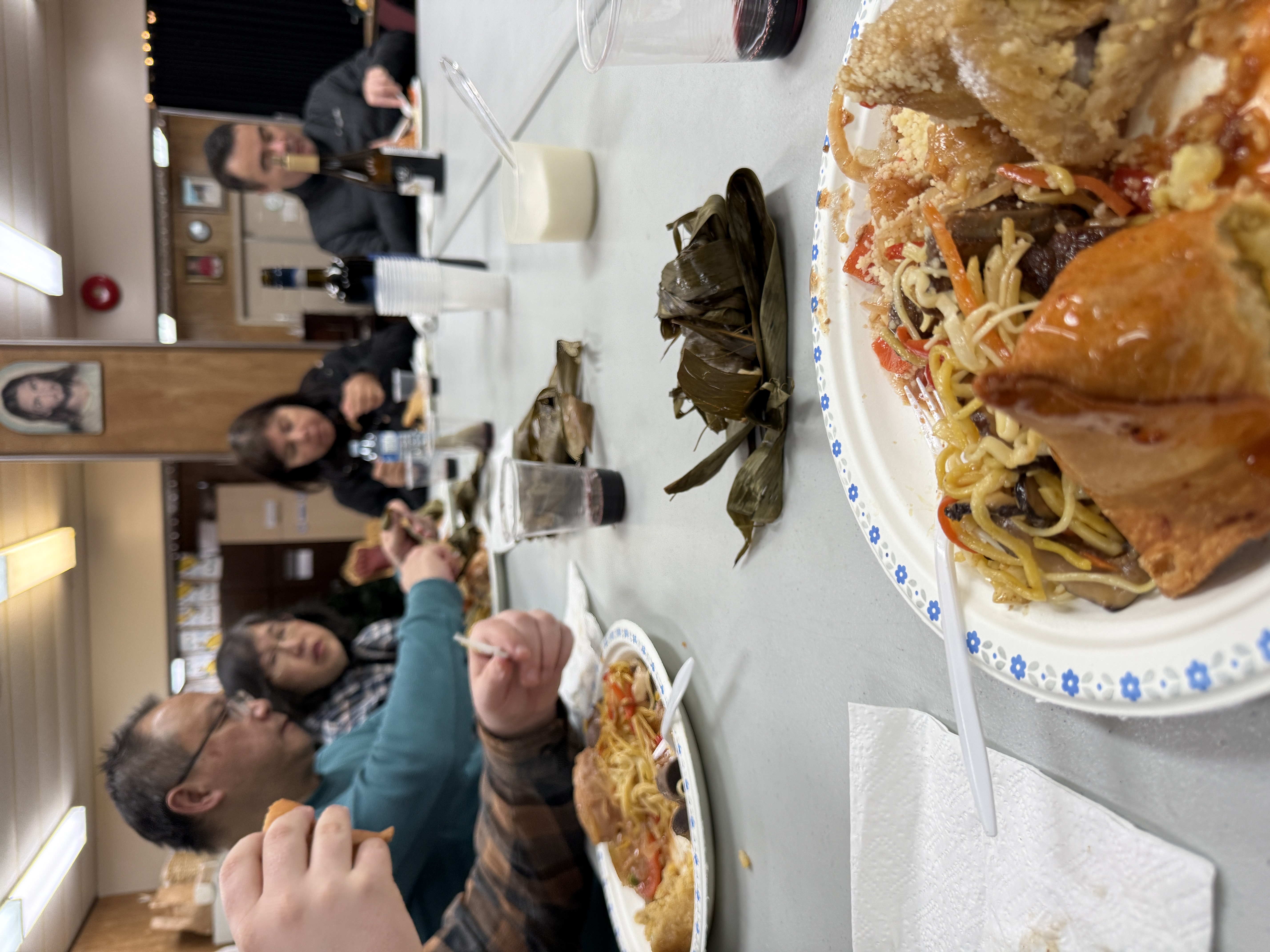 Close view of shared plates of food and wrapped rice parcels